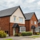 New build small detached brick built home frontages with established garden shrub planting