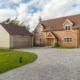 New build cottage style dormer brick property with timbered canopy double detached garage and sweeping block paved driveway