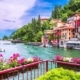 Lake Como Italy summertime image of lakeside multi coloured buildings boats and flower baskets