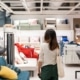 Woman with long brown hair in furniture shop looking at display of sofas and cushions